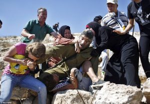 2BBEAFEB00000578-3214441-Palestinians_scuffle_with_an_Israeli_soldier_as_they_try_to_prev-a-20_1440789212166